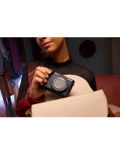Mujer sosteniendo cámara en ambiente interior acogedor, capturado con Canon PowerShot V1 – Cámara compacta 4K para vlogg