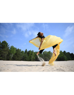 A woman jumping on a sandy beach wearing a flowing yellow fabric, captured with Nikon NIKKOR Z 24-70mm f/2.8 S II Lens A woman jumping on a sandy beach wearing a flowing yellow fabric, captured with Nikon NIKKOR Z 24-70mm f/2.8 S II Lens