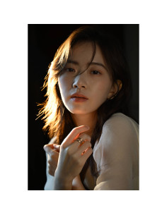 A young woman with soft lighting on her face gazes thoughtfully at the, captured with Nikon NIKKOR Z 24-70mm f/2.8 S II Lens A young woman with soft lighting on her face gazes thoughtfully at the, captured with Nikon NIKKOR Z 24-70mm f/2.8 S II Lens