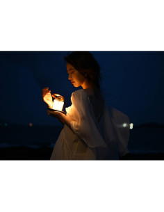 A woman in a flowing white dress holding a glowing lantern by the beach, captured with Nikon NIKKOR Z 24-70mm f/2.8 S II Lens A woman in a flowing white dress holding a glowing lantern by the beach, captured with Nikon NIKKOR Z 24-70mm f/2.8 S II Lens