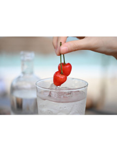 A hand placing cherries on a cocktail glass filled with ice and water, captured with Nikon NIKKOR Z 24-70mm f/2.8 S II Lens A hand placing cherries on a cocktail glass filled with ice and water, captured with Nikon NIKKOR Z 24-70mm f/2.8 S II Lens