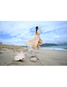 A woman in a flowy dress stands on a sandy beach with shells and a bott, captured with Nikon NIKKOR Z 24-70mm f/2.8 S II Lens A woman in a flowy dress stands on a sandy beach with shells and a bott, captured with Nikon NIKKOR Z 24-70mm f/2.8 S II Lens