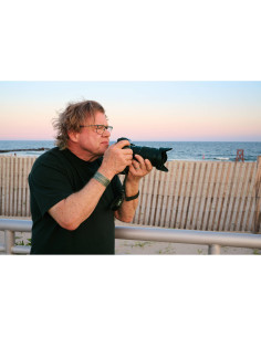 Hombre tomando fotos en la playa al atardecer con fondo de mar y cielo suave, capturado con Nikon NIKKOR Z 24-70mm f/2.8 S II Hombre tomando fotos en la playa al atardecer con fondo de mar y cielo suave, capturado con Nikon NIKKOR Z 24-70mm f/2.8 S II
