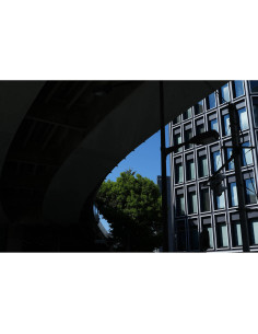 Una escena urbana con edificios y árboles bajo un cielo azul, capturado con Sony FE 28-70mm f/2 GM Una escena urbana con edificios y árboles bajo un cielo azul, capturado con Sony FE 28-70mm f/2 GM