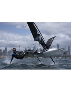 Navigateur en action sur un bateau à foil avec la ville en arrière-plan, capture au Sony FE 50-150mm f/2 GM
