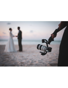 Boda en la playa al atardecer con una cámara en un estabilizador, capturado con Sony FE 50-150mm f/2 GM