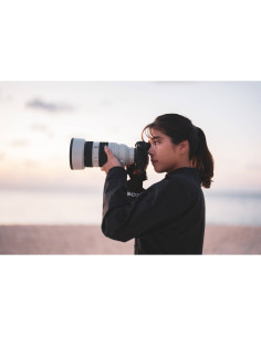 Femme photographiant au bord de la mer au crépuscule, capture au Sony FE 50-150mm f/2 GM