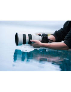 Una mano sosteniendo una cámara cerca del agua, reflejos visibles en la superficie, capturado con Sony FE 50-150mm f/2 GM