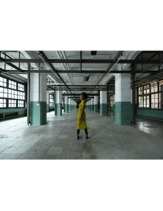 A woman in a yellow dress spins in an empty industrial space, captured with Sony FE 16mm f/1.8 G A woman in a yellow dress spins in an empty industrial space, captured with Sony FE 16mm f/1.8 G