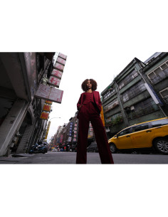 A woman in a red suit stands confidently in an urban street setting, captured with Sony FE 16mm f/1.8 G A woman in a red suit stands confidently in an urban street setting, captured with Sony FE 16mm f/1.8 G