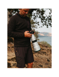 A person adjusting a camera while standing in a natural setting near water, captured with Fujifilm XF 500mm f/5.6 R LM OIS WR A person adjusting a camera while standing in a natural setting near water, captured with Fujifilm XF 500mm f/5.6 R LM OIS WR