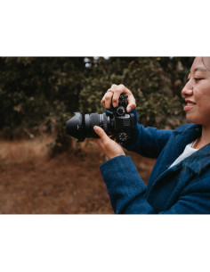 Person holding a camera in a nature setting with trees in the background, captured with Fujifilm XF 16-55mm f/2.8 R LM WR II Person holding a camera in a nature setting with trees in the background, captured with Fujifilm XF 16-55mm f/2.8 R LM WR II