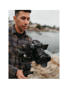 Man holding a camera gimbal near the water, showing a coastal scenery, captured with Fujifilm XF 16-55mm f/2.8 R LM WR II Man holding a camera gimbal near the water, showing a coastal scenery, captured with Fujifilm XF 16-55mm f/2.8 R LM WR II