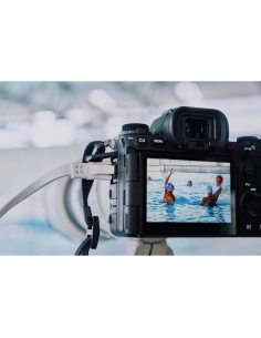 Photographe au bord de la piscine, capturant des nageurs en pleine action sous une lumière nature, capture au Sony Alpha 1 II
