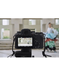 Photographe en pleine capture d'une danseuse sur scène avec un fond moderne, capture au Sony Alpha 1 II