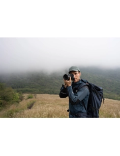 A photographer in a green landscape, capturing a scene with a ca, captured with Sony Alpha 7 V – Full Frame Mirrorless Camera A photographer in a green landscape, capturing a scene with a ca, captured with Sony Alpha 7 V – Full Frame Mirrorless Camera