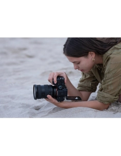 A young woman capturing photos on the beach, focused and lying o, captured with Sony Alpha 7 V – Full Frame Mirrorless Camera A young woman capturing photos on the beach, focused and lying o, captured with Sony Alpha 7 V – Full Frame Mirrorless Camera