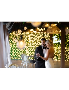 Pareja bailando bajo luces brillantes y decorativas en un ambiente romántico, capturado con Canon RF 135mm f/1.8 L IS USM
