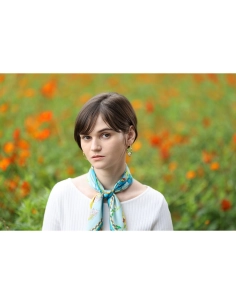 A young woman in a light sweater and scarf stands in a flower field with bright, captured with Canon RF 135mm f/1.8 L IS USM A young woman in a light sweater and scarf stands in a flower field with bright, captured with Canon RF 135mm f/1.8 L IS USM