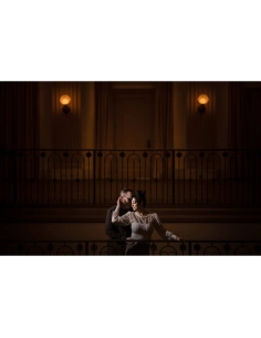 A couple embracing in a warmly lit, elegant balcony setting, captured with Canon RF 135mm f/1.8 L IS USM A couple embracing in a warmly lit, elegant balcony setting, captured with Canon RF 135mm f/1.8 L IS USM