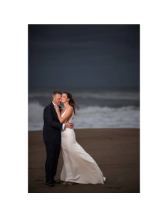 A couple embracing on a beach during sunset, waves in the background, moody atmo, captured with Canon RF 135mm f/1.8 L IS USM A couple embracing on a beach during sunset, waves in the background, moody atmo, captured with Canon RF 135mm f/1.8 L IS USM