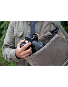 Photographe avec un sac, tenant un appareil Nikon en pleine nature Photographe avec un sac, tenant un appareil Nikon en pleine nature