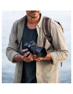 Homme tenant un appareil photo près de l'eau, ambiance décontractée, capture au Nikon Z 50mm f/1.4 Homme tenant un appareil photo près de l'eau, ambiance décontractée, capture au Nikon Z 50mm f/1.4