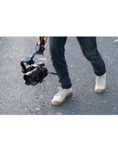 Un photographe marche avec un stabilisateur, en plein milieu d'une rue, capture au Nikon Z 50mm f/1.4 Un photographe marche avec un stabilisateur, en plein milieu d'une rue, capture au Nikon Z 50mm f/1.4