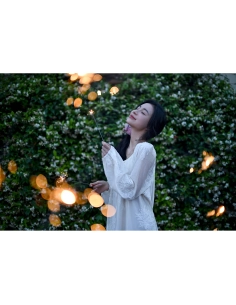 Femme souriante avec des étincelles dans un jardin fleuri, capture au Nikon Z 50mm f/1.4 Femme souriante avec des étincelles dans un jardin fleuri, capture au Nikon Z 50mm f/1.4