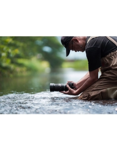 Photographe en waders dans un cours d'eau, capturant des images naturelles, capture au Sony FE 100mm f/2.8 Macro GM