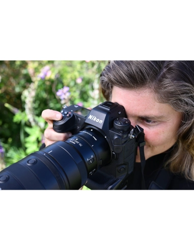 A photographer capturing a moment outdoors with nature in the background, captured with Nikon Z 70-200mm f/2.8 VR S II