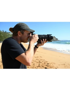 A person photographing at the beach with a camera, sunny weather, ocean waves i, captured with Nikon Z 70-200mm f/2.8 VR S II A person photographing at the beach with a camera, sunny weather, ocean waves i, captured with Nikon Z 70-200mm f/2.8 VR S II