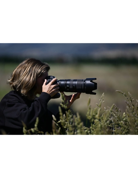 Una persona fotografiando en un entorno natural con hierbas, capturado con Nikon NIKKOR Z 70-200mm f/2.8 VR S II