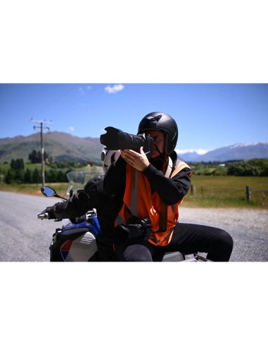 A person wearing an orange vest and helmet on a motorcycle photographing the la, captured with Nikon Z 70-200mm f/2.8 VR S II