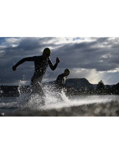 Two swimmers running through water against a dramatic sky, captured with Nikon Z 70-200mm f/2.8 VR S II