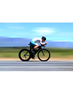 A cyclist in motion on a road against a blurred background of fields and sky, captured with Nikon Z 70-200mm f/2.8 VR S II A cyclist in motion on a road against a blurred background of fields and sky, captured with Nikon Z 70-200mm f/2.8 VR S II