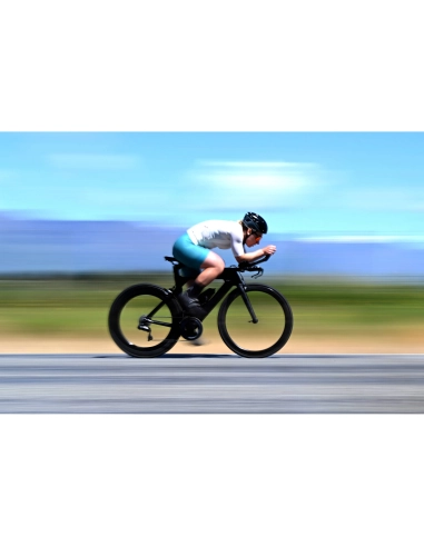 A cyclist in motion on a road against a blurred background of fields and sky, captured with Nikon Z 70-200mm f/2.8 VR S II