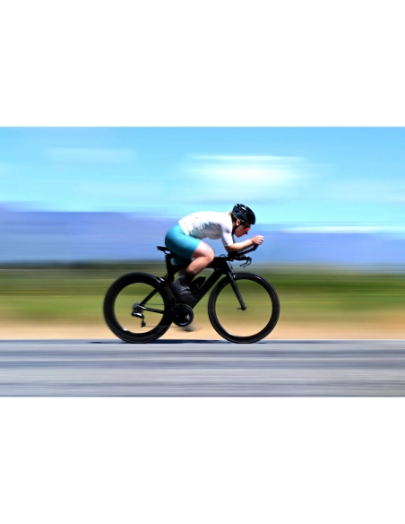 Ciclista en movimiento sobre una carretera en un paisaje despejado y vib, capturado con Nikon NIKKOR Z 70-200mm f/2.8 VR S II