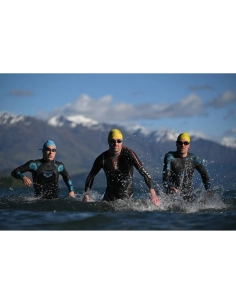 Three swimmers in wet suits emerging from water with mountains in the backgroun, captured with Nikon Z 70-200mm f/2.8 VR S II Three swimmers in wet suits emerging from water with mountains in the backgroun, captured with Nikon Z 70-200mm f/2.8 VR S II