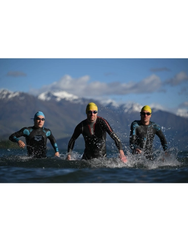 Three swimmers in wet suits emerging from water with mountains in the backgroun, captured with Nikon Z 70-200mm f/2.8 VR S II