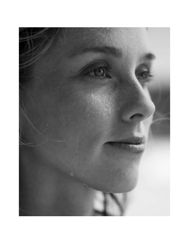 Close-up of a woman's face with water droplets, thoughtful expression, captured with Nikon Z 70-200mm f/2.8 VR S II