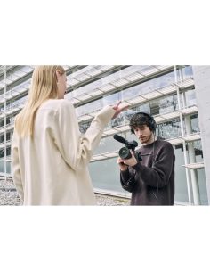 Joven con cámara grabando a modelo en un entorno moderno y luminoso, capturado con Sony a7R VI Joven con cámara grabando a modelo en un entorno moderno y luminoso, capturado con Sony a7R VI