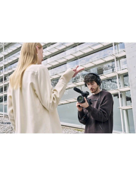 Joven con cámara grabando a modelo en un entorno moderno y luminoso, capturado con Sony a7R VI