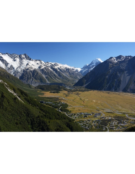 paisaje montañoso con un valle verde y montañas nevadas, capturado con Sony a7R VI