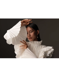 Modelo con blusa blanca de volantes en un fondo oscuro, mostrando poses elegantes y expresivas, capturado con Sony a7R VI Modelo con blusa blanca de volantes en un fondo oscuro, mostrando poses elegantes y expresivas, capturado con Sony a7R VI