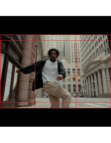 A man dancing in an urban setting with tall buildings around him, captured with Canon EOS R6 V Camera Body