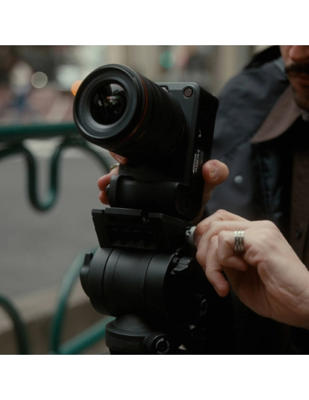 A photographer adjusts a camera on a tripod in an urban environmen, captured with Canon EOS R6 V + RF 20-50mm f/4 L IS USM PZ