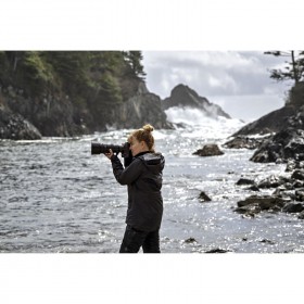 Woman photographing the ocean waves with a large camera by the shore, captured with Nikon Z 400mm f/4.5 VR S Woman photographing the ocean waves with a large camera by the shore, captured with Nikon Z 400mm f/4.5 VR S