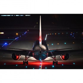 A plane on a runway lit by colorful lights, evening ambiance creating a dramatic atmo, captured with Nikon Z 400mm f/4.5 VR S A plane on a runway lit by colorful lights, evening ambiance creating a dramatic atmo, captured with Nikon Z 400mm f/4.5 VR S