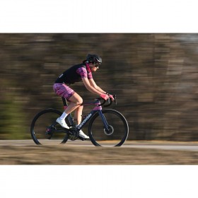 A cyclist in motion wearing a pink outfit riding on a road, captured with Nikon Z 400mm f/4.5 VR S A cyclist in motion wearing a pink outfit riding on a road, captured with Nikon Z 400mm f/4.5 VR S